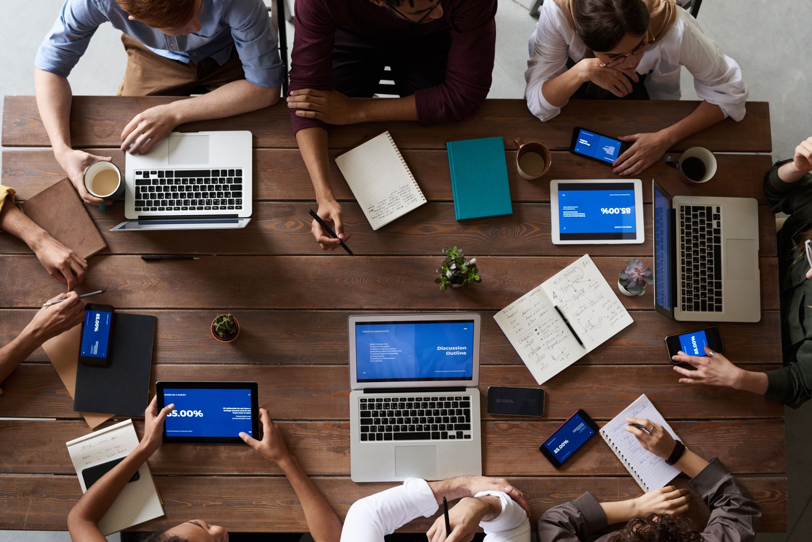 A planning meeting around a table with laptops and notebooks showing retirement and savings topics